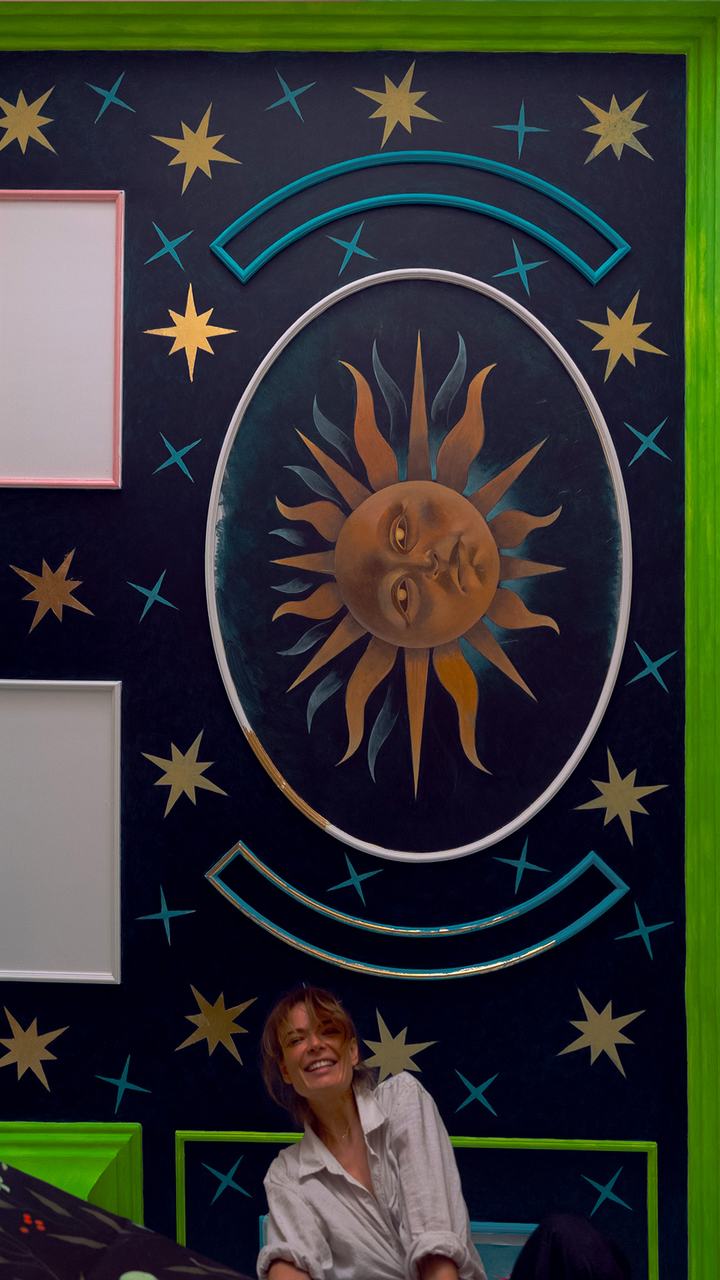Completed sun mural in gold and teal on a midnight blue wall