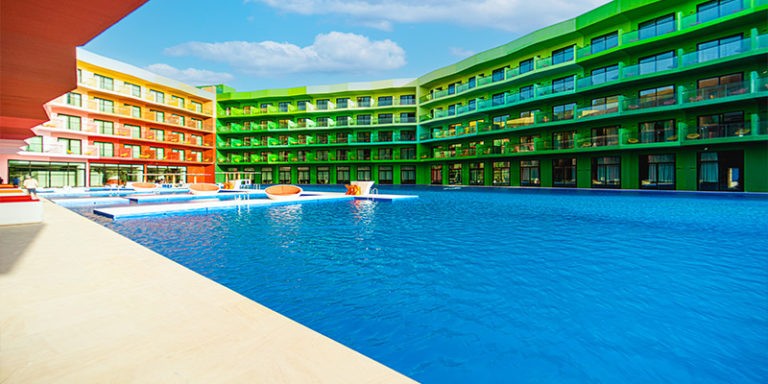 Colorful resort-style exterior of Voco Monaco Dubai overlooking private beach