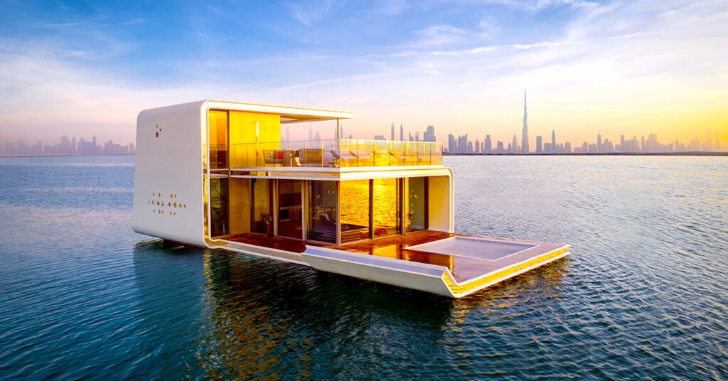 Luxury floating villa in Dubai with modern glass design, sunset view, and skyline backdrop