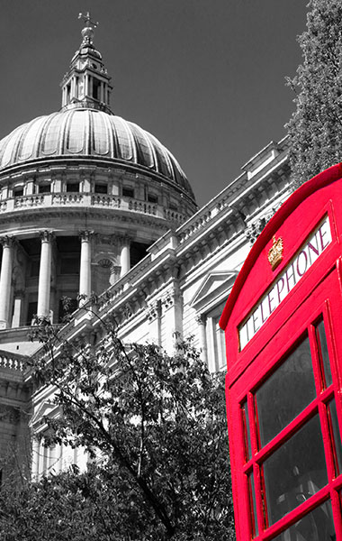 Red London telephone booth in front of historic dome building, classic English city scene for Dubai hotel event